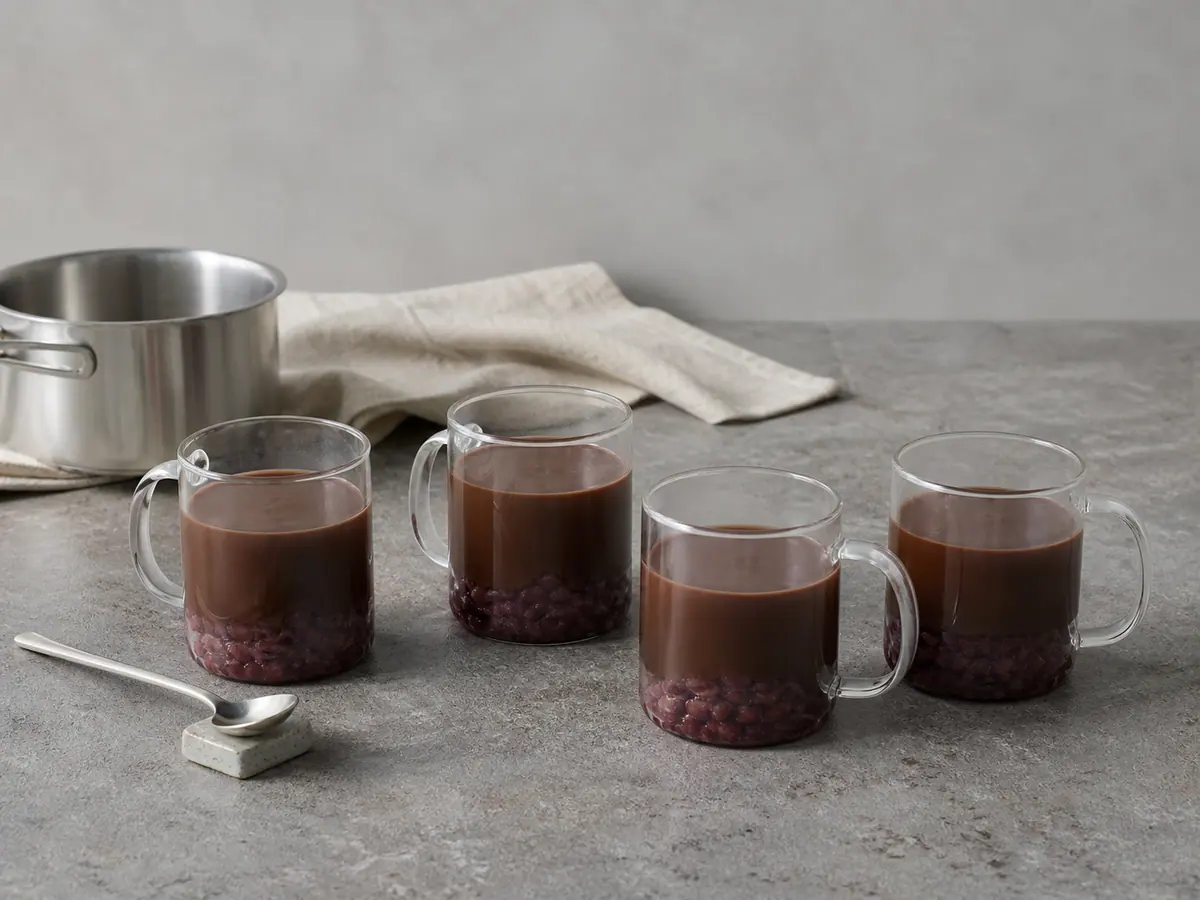 Four clear mugs with even cocoa layers above distinct sweet adzuki bases