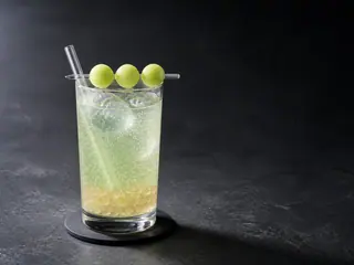 Pale green honeydew soda with tapioca pearls and three melon balls