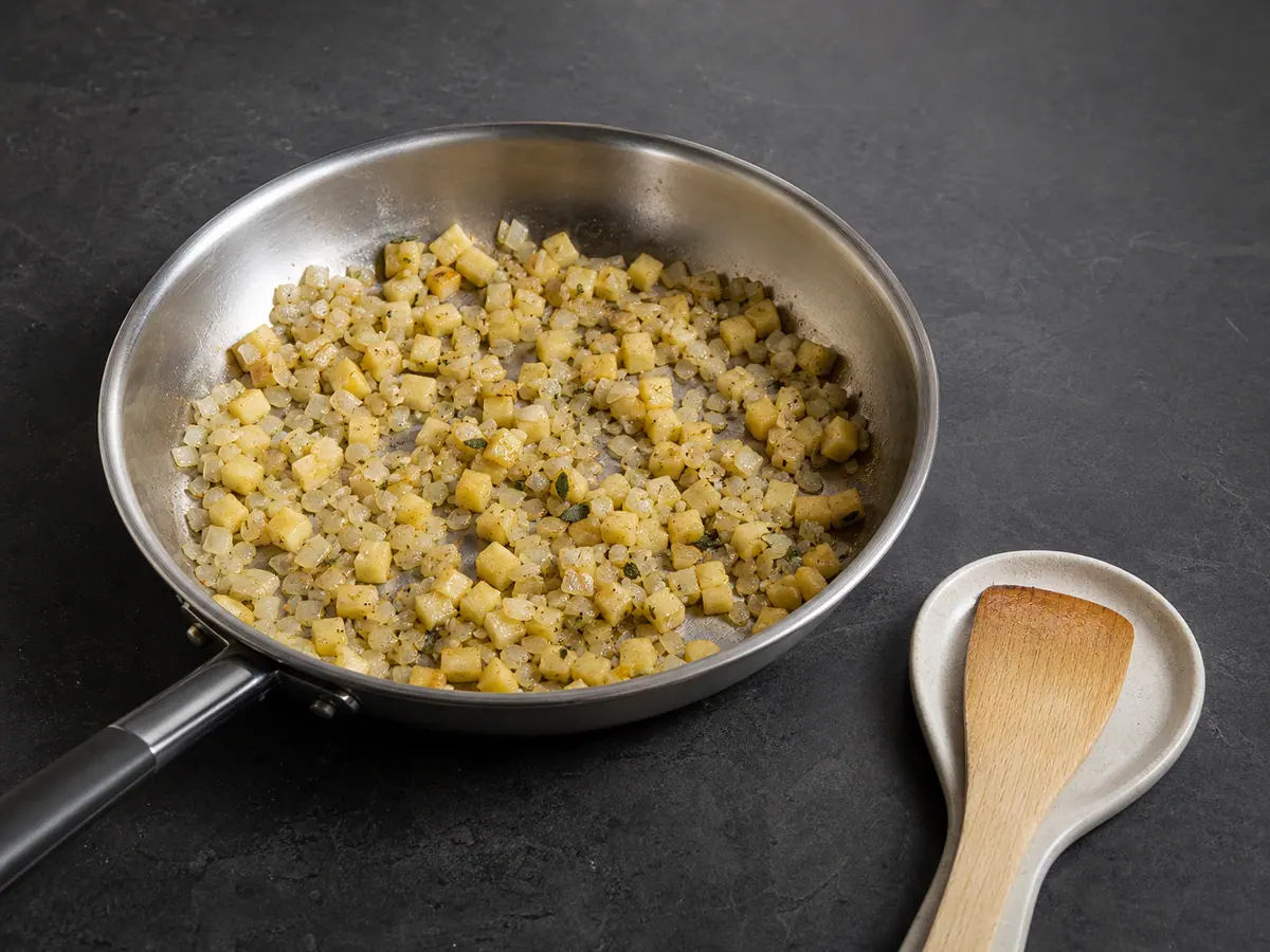 Nearly dry cooked apple and onion with sage in a skillet