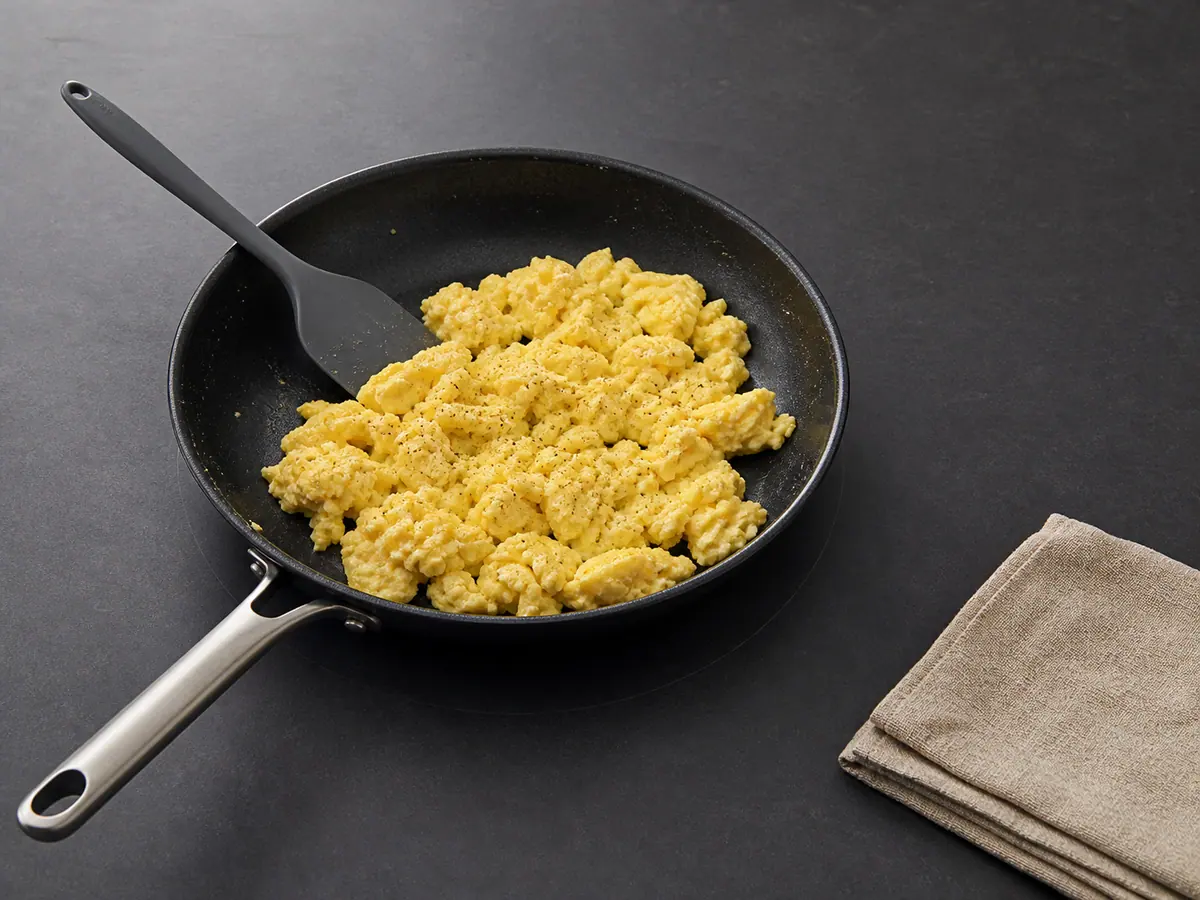 Fully set broad scrambled egg curds in a nonstick skillet