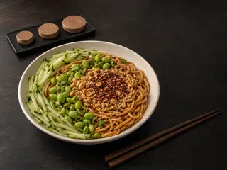 Chili crisp noodle bowl with cucumber, edamame, scallions, peanuts, sesame, and three topping bands