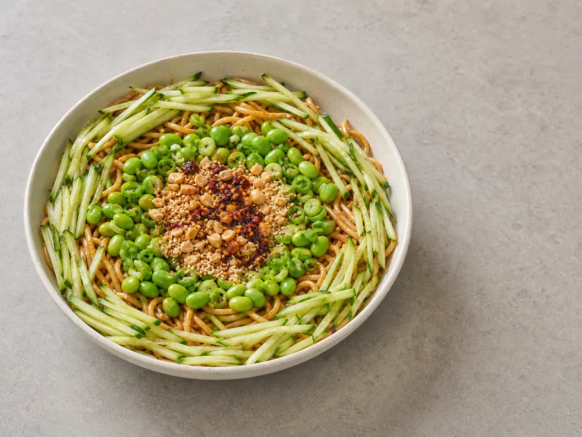 Sesame chili noodles arranged with cucumber, edamame, scallions, peanuts, sesame, and chili crisp in three bands