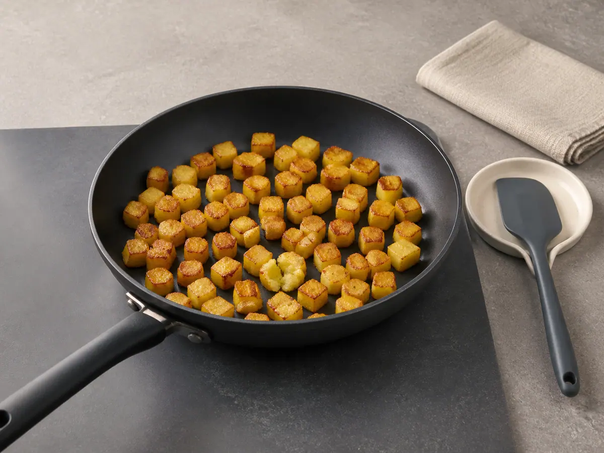Tender 1 cm Yukon Gold potato cubes with deeply browned sides in an uncrowded skillet