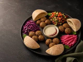 Four-position falafel pita platter with tahini and colorful toppings