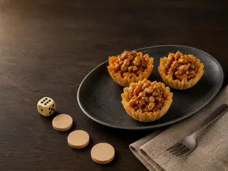 Three honey walnut phyllo tartlets beside a tabletop quest route