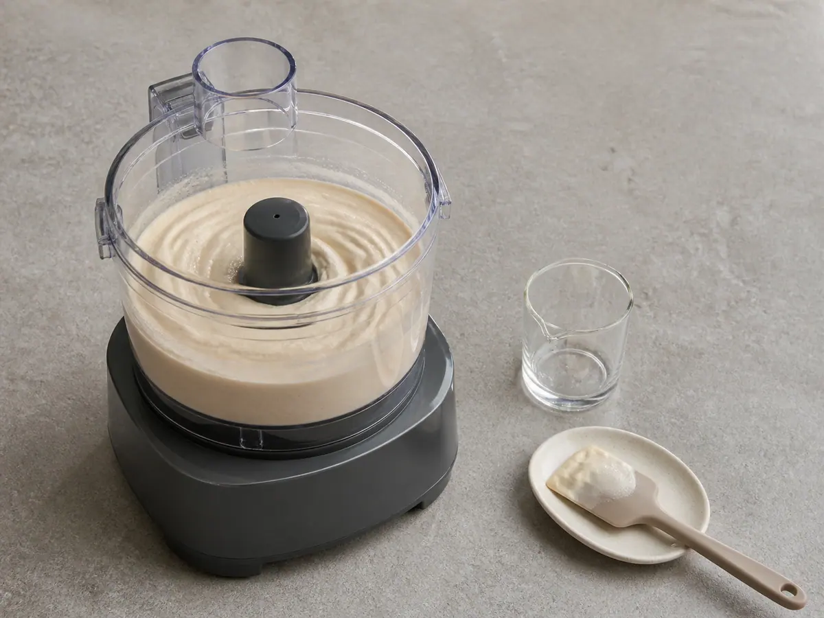 Pale whipped tahini emulsion in a food processor before chickpeas are added