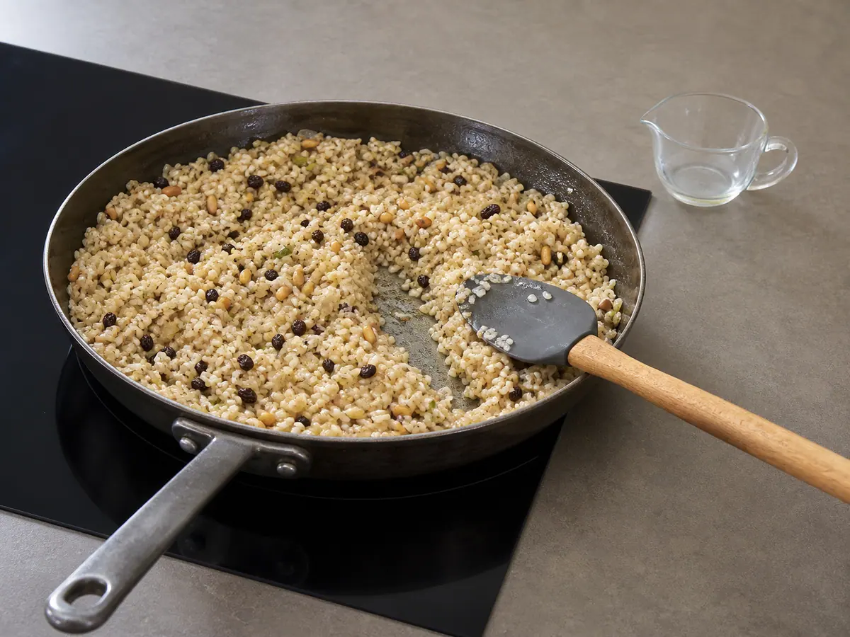 Partially cooked rice filling with most liquid absorbed in a wide skillet