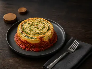 Upright spinach ricotta lasagna spiral with tomato sauce and browned mozzarella