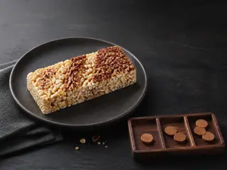 Single maple pecan popcorn bar with three increasingly dense pecan bands