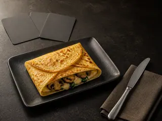 Envelope crocante de crepe com cogumelos e espinafre, Gruyère derretido e três cartas em branco ao lado