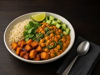 Sweet potato curry bowl with brown rice, chickpeas, roasted sweet potato, cucumber, spinach, cilantro, and lime
